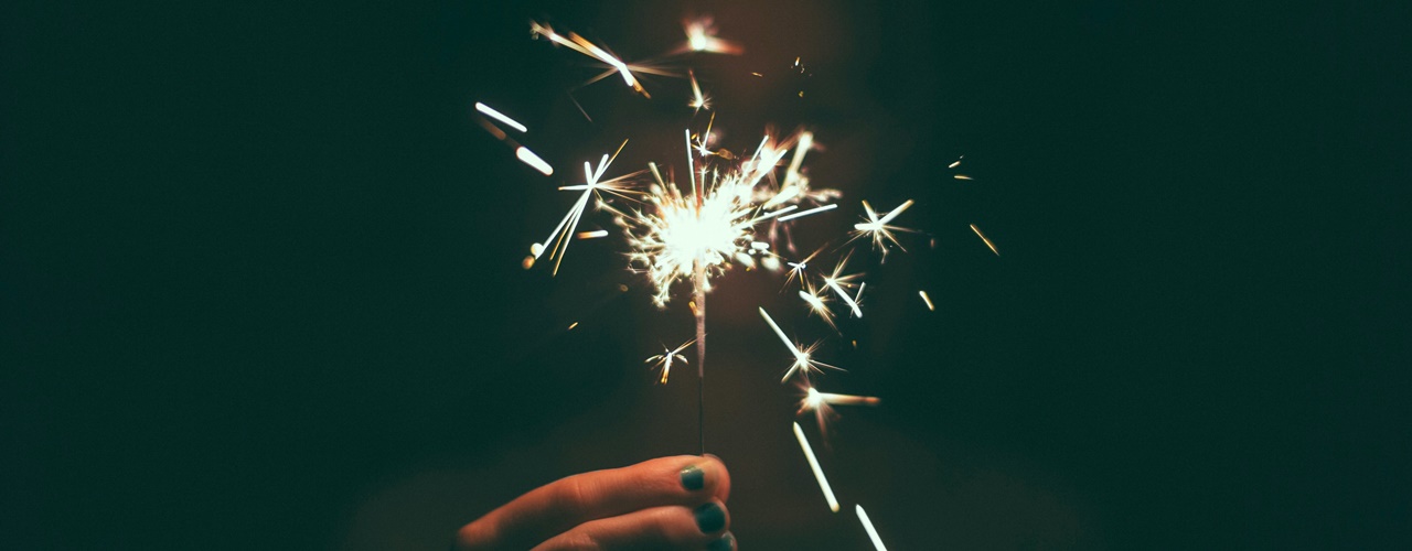 A person holding a sparkler during a New Year Holiday