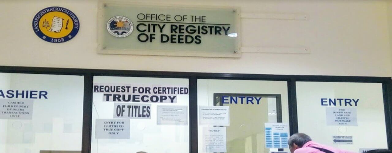 A man at the assement window of the City Registry of Deeds for Land Title process.