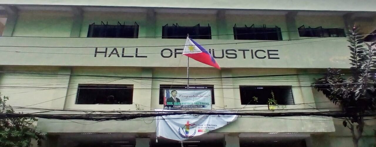 A flag in front of the Hall of Justice where to pay Small Claims Philippines Filing Fee
