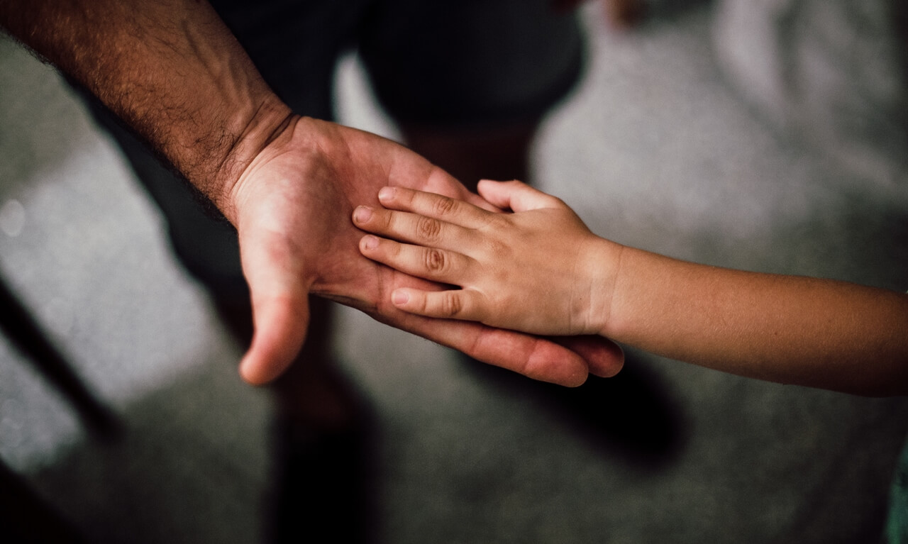 A father holding his child's hands symbolizing Child Support Philippines
