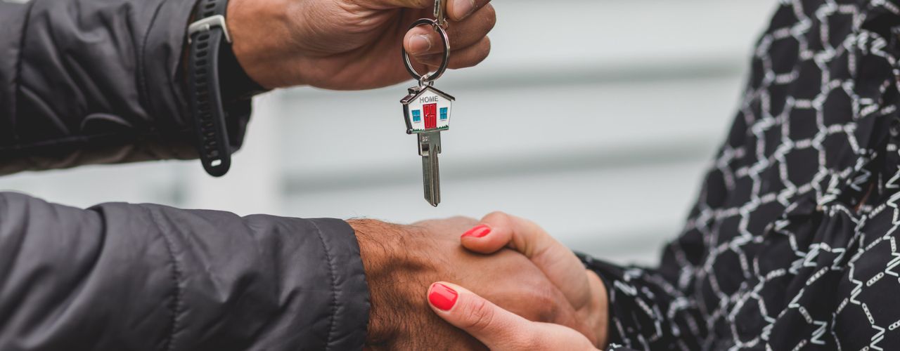 Man giving a woman key to his property as dpnation or inheritance