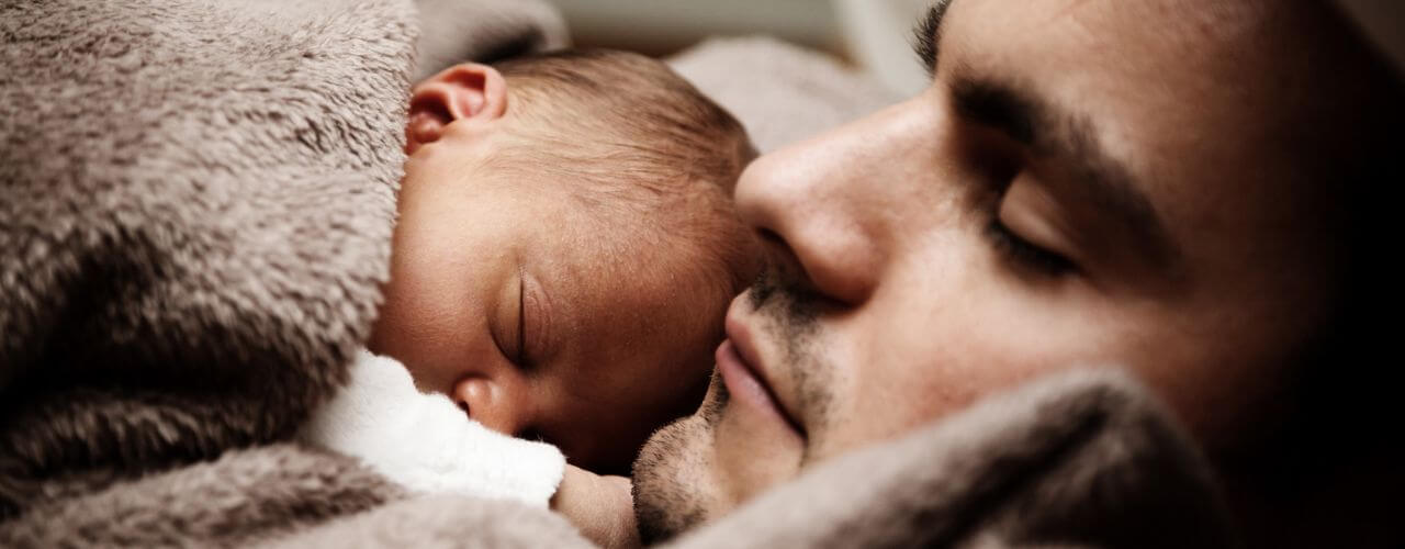 Father and a baby sleeping peacefully together.