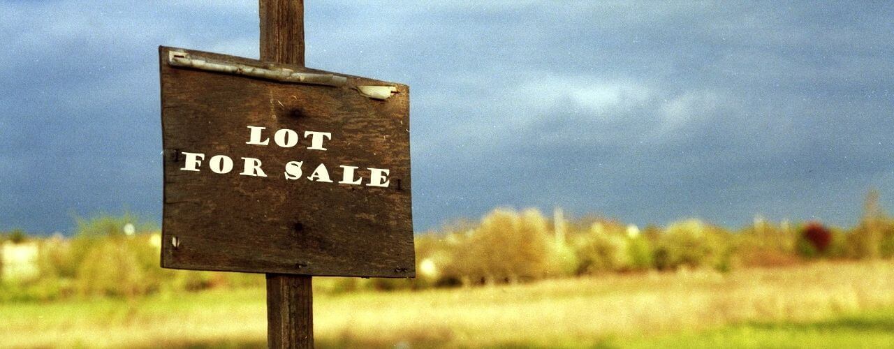 A wood sign of lot for sale.