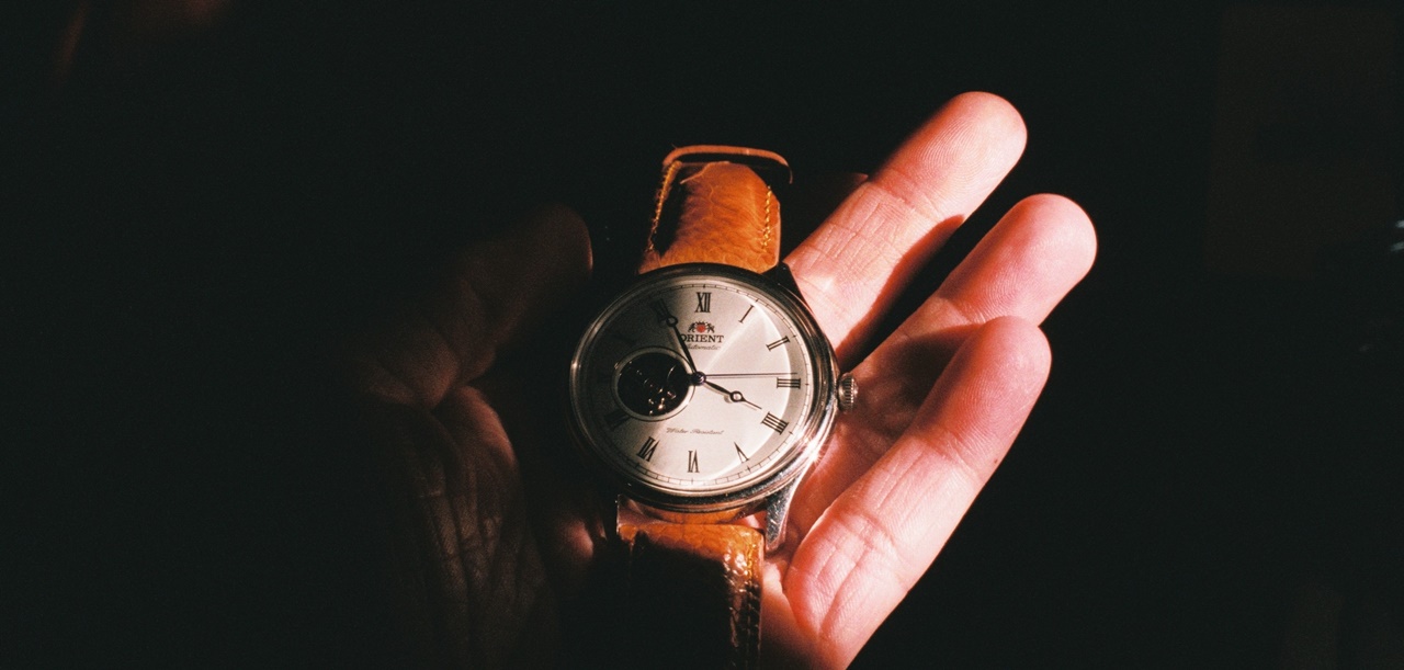A hand holding a wrist watch
